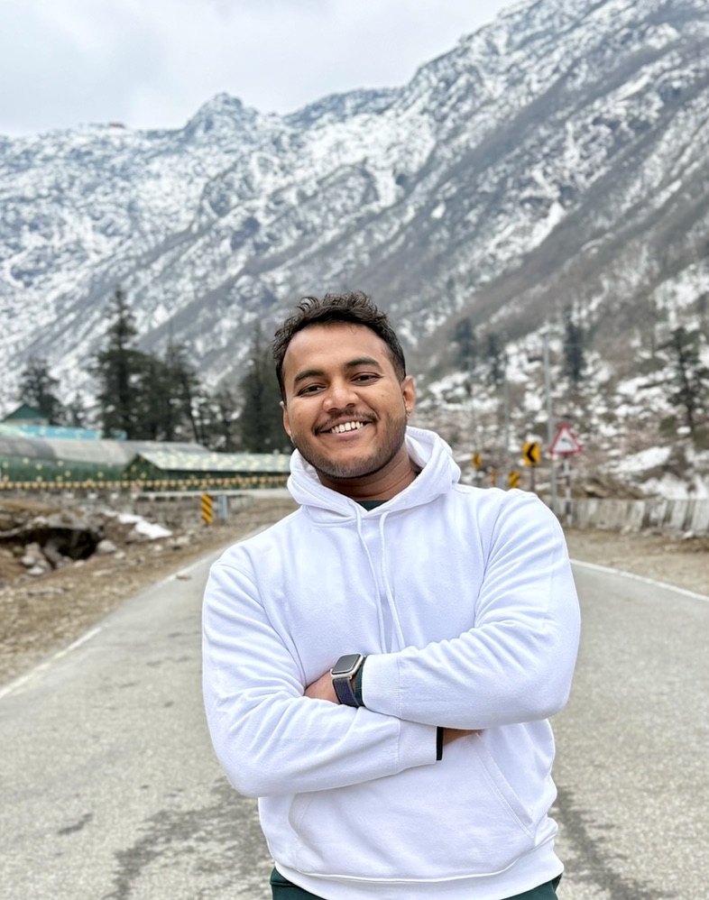 Aayush in white hoodie — mountains